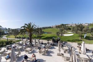 a group of people sitting around tables and chairs at Hotel Duquesa Golf Club in San Luis de Sabinillas