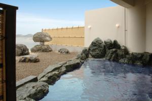 a pool of water with rocks in front of a building at シーパの湯 Seapa Makoto in Matsuyama