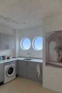 a kitchen with a sink and a washing machine at PAK Central apartment Odense C in Odense
