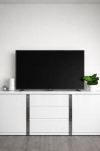 a flat screen tv sitting on top of a white entertainment center at PAK Central apartment Odense C in Odense +6 photos
