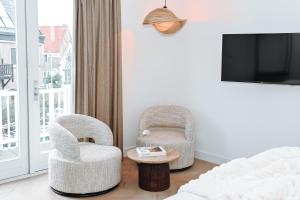 two chairs and a table in a room with a tv at Residence Paradis in Zandvoort