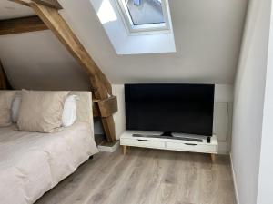 a bedroom with a flat screen tv and a bed at Amelia in Saint-Aignan
