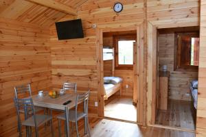 a dining room in a log cabin with a table and chairs at Domki letniskowe KEYA in Gąski