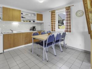 a kitchen with a table and chairs and a clock at Chata Křemenka in Lauterwasser