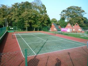 a tennis court with a net on top of it at Chalet Thirtyone in Deal
