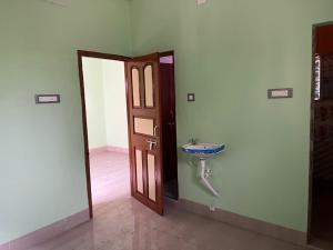 a bathroom with a sink next to a door at Radhashyam in Durgāpur