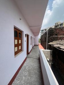 a corridor of a white building with a window at Radhashyam in Durgāpur