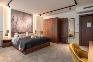 a bedroom with a large bed and two chairs at Dolce Vita Hotel Art in Budapest +17 photos