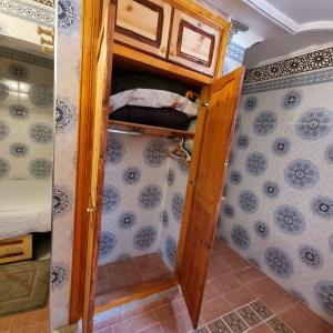 a small room with a wooden door and a bedroom at Momo's villa in Aït Ourir