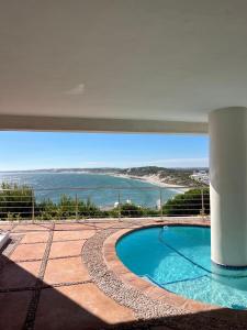 a swimming pool with a view of the ocean at Endless blue ocean view escape in Langebaan +12 photos