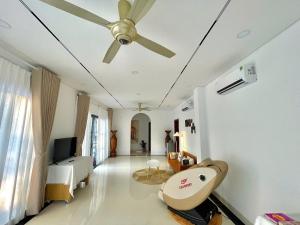 a living room with a ceiling fan and a bedroom at KIMO HOUSE Khem Beach in Phú Quốc