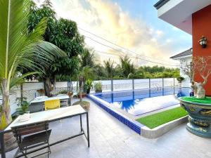 a patio with a pool and a table and chairs at KIMO HOUSE Khem Beach in Phú Quốc