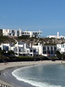 a view of a beach with white buildings in the background at Endless blue ocean view escape in Langebaan
