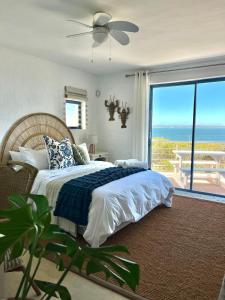 a bedroom with a bed with a view of the ocean at Endless blue ocean view escape in Langebaan