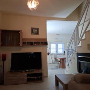 a living room with a flat screen tv and a staircase at Suntime villa Laguna in Bigova