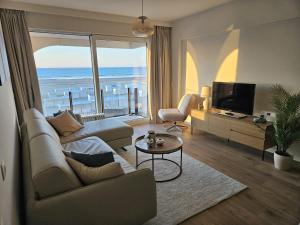 a living room with a view of the ocean at Isola Bella - Luxe Verblijf op de Zeedijk met Panoramisch Uitzicht in Blankenberge