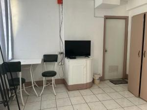 a room with a desk with a television and two chairs at En Pensionne, Lodging in Iloilo City +7 photos