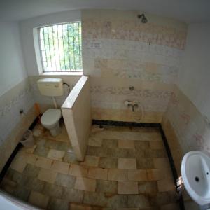 a bathroom with a tub and a toilet and a sink at New Creation Guest House in Auroville +65 photos