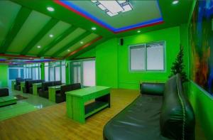 a green room with a couch and a table at Hotel Sambridhi in Panepa