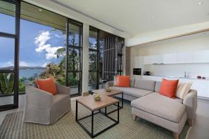 a living room with a couch and chairs and windows at Hyatt Regency Phuket Resort in Kamala Beach