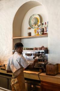 a man standing in a kitchen preparing food at Petti Petti Beach Club- Mirissa in Mirissa +71 photos