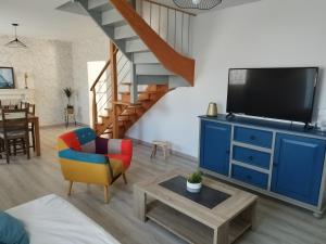 a living room with a blue entertainment center with a tv at Petite Maison a deux pas du centre in Le Faou