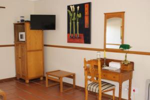 a room with a desk and a table with a mirror at Chez Esme Guest House in Roodepoort