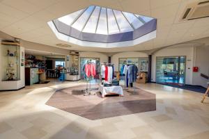 a clothing store with a skylight in a building at Brit Hotel Golfhotel Saint Samson in Pleumeur-Bodou