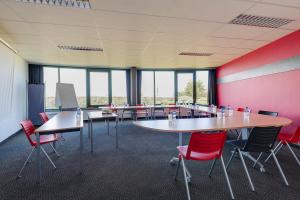 a conference room with tables and chairs and windows at Brit Hotel Golfhotel Saint Samson in Pleumeur-Bodou +64 photos