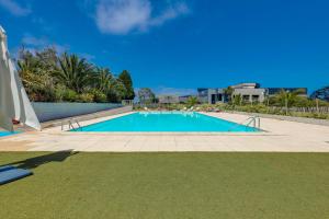 a large swimming pool in a yard with a blue at Brit Hotel Golfhotel Saint Samson in Pleumeur-Bodou