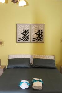 a bedroom with a bed with three pictures on the wall at SudOceania Apartment in Lamezia Terme