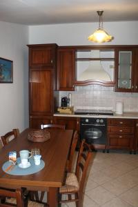 a kitchen with a wooden table and a dining room at SudOceania Apartment in Lamezia Terme