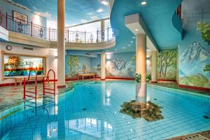 a pool in a hotel with a mural at Wellnesshotel Mitterwirt in Dienten am Hochkönig