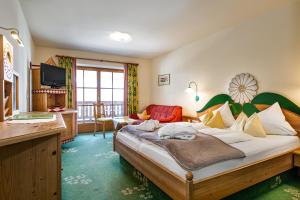 a bedroom with a large bed and a living room at Wellnesshotel Mitterwirt in Dienten am Hochkönig