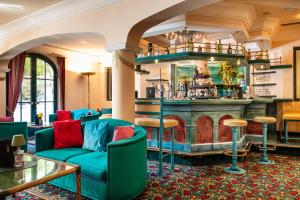 a lobby with a bar with blue chairs at Wellnesshotel Mitterwirt in Dienten am Hochkönig