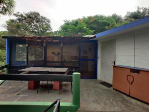 a blue building with a table at New Creation Guest House in Auroville