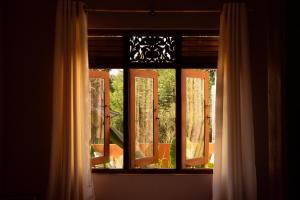 a window with a view of a porch with chairs at Bakamuna Villa in Dickwella