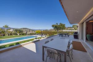 a patio with a table and chairs and a swimming pool at REF 2193 - Super Cannes Villa for rent in Vallauris