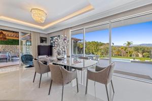 a dining room with a table and chairs and windows at REF 2193 - Super Cannes Villa for rent in Vallauris +32 photos