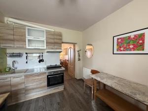 a kitchen with wooden cabinets and a wooden table at Viesu nams "Vijās" in Degumuiža
