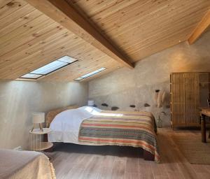 a bedroom with a bed and a wooden ceiling at Wellbeing guesthouse Casa é Connosco in Alvaiázere