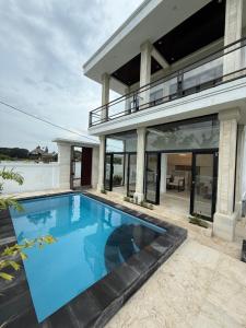 a swimming pool in front of a house at Murni’s House in Lovina