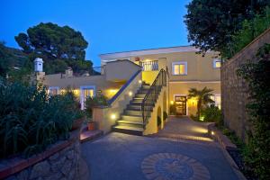 a house with stairs and lights in the night at Hotel Villa Ceselle in Anacapri
