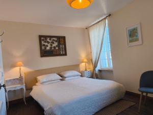 a bedroom with a large bed and a window at Domfront - Numero CINQ in Domfront