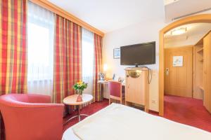 ザルツブルクにあるオーストリア クラシック ホテル ヘレのベッドとテレビ付きのホテルルーム
