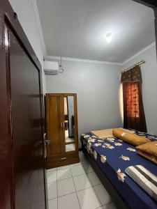 a bedroom with a bed and a door and a window at Homestay lembayung senja in Bulakbenda