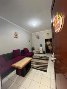 a living room with a purple couch and a table at Homestay lembayung senja in Bulakbenda
