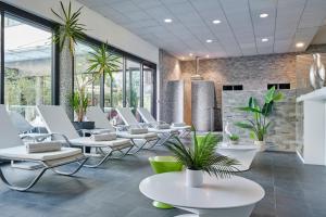 a waiting room with white chairs and tables at Hôtel Restaurant Athena Spa in Strasbourg