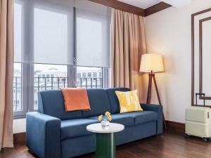 a blue couch in a living room with a window at Numa Berlin Potsdamer Platz in Berlin