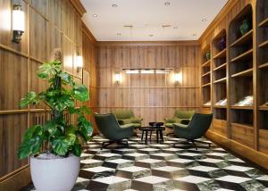 a lobby with green chairs and a potted plant at Numa Berlin Potsdamer Platz in Berlin